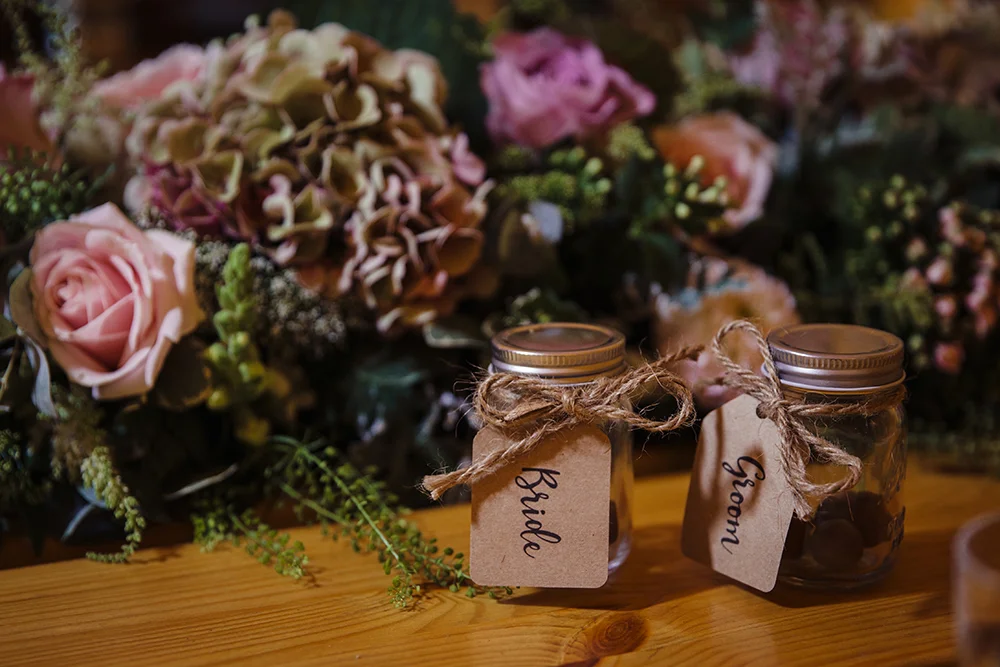Place cards on favour jars at Alice and Steve's tipi wedding